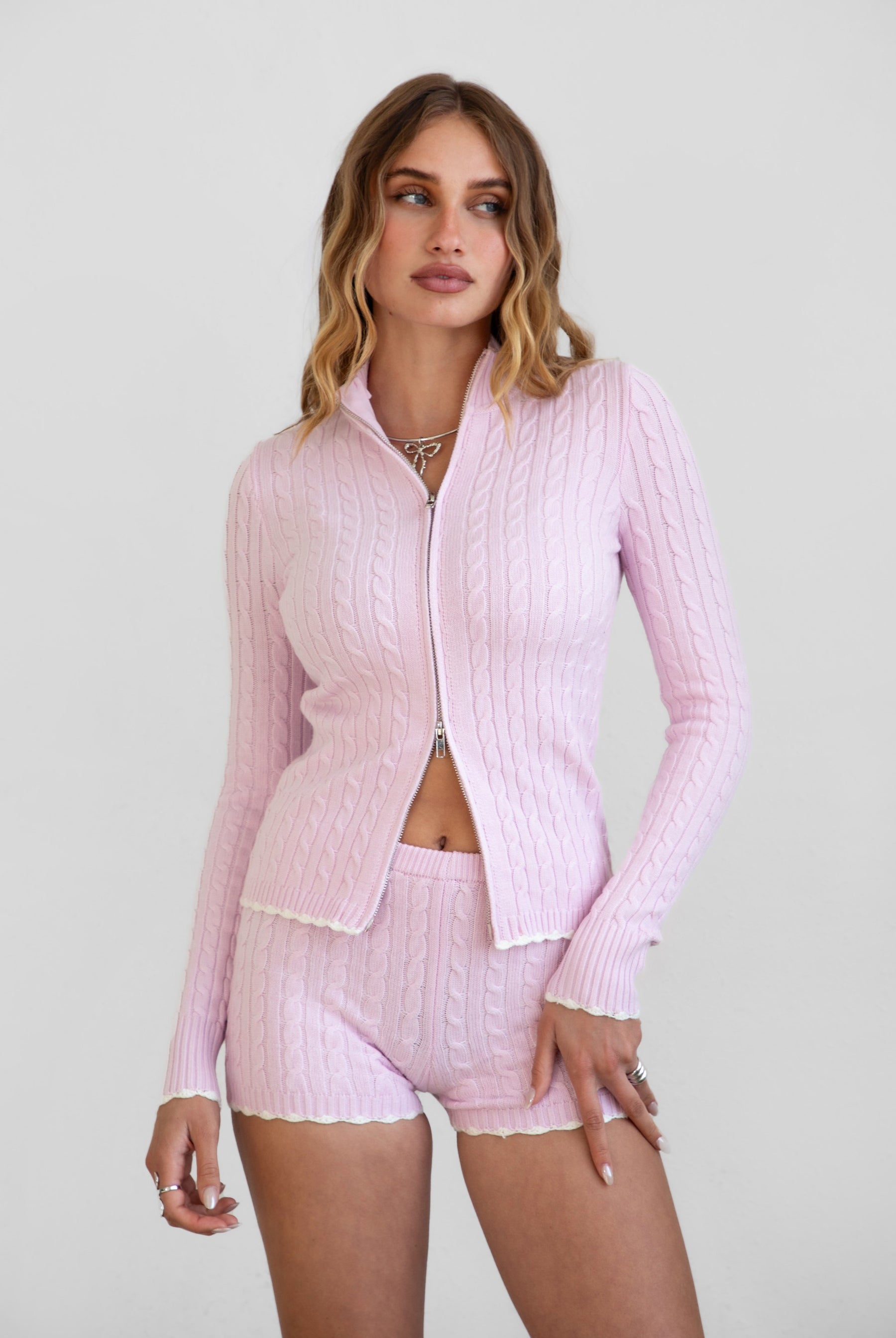 TIC TOC TPC31027 CLINE Cable Knit Two-Piece Lounge Short Set in brown and blush. Features a zip-up cropped sweater with a high mock neck, ribbed contrast trim, and matching mid-rise shorties.