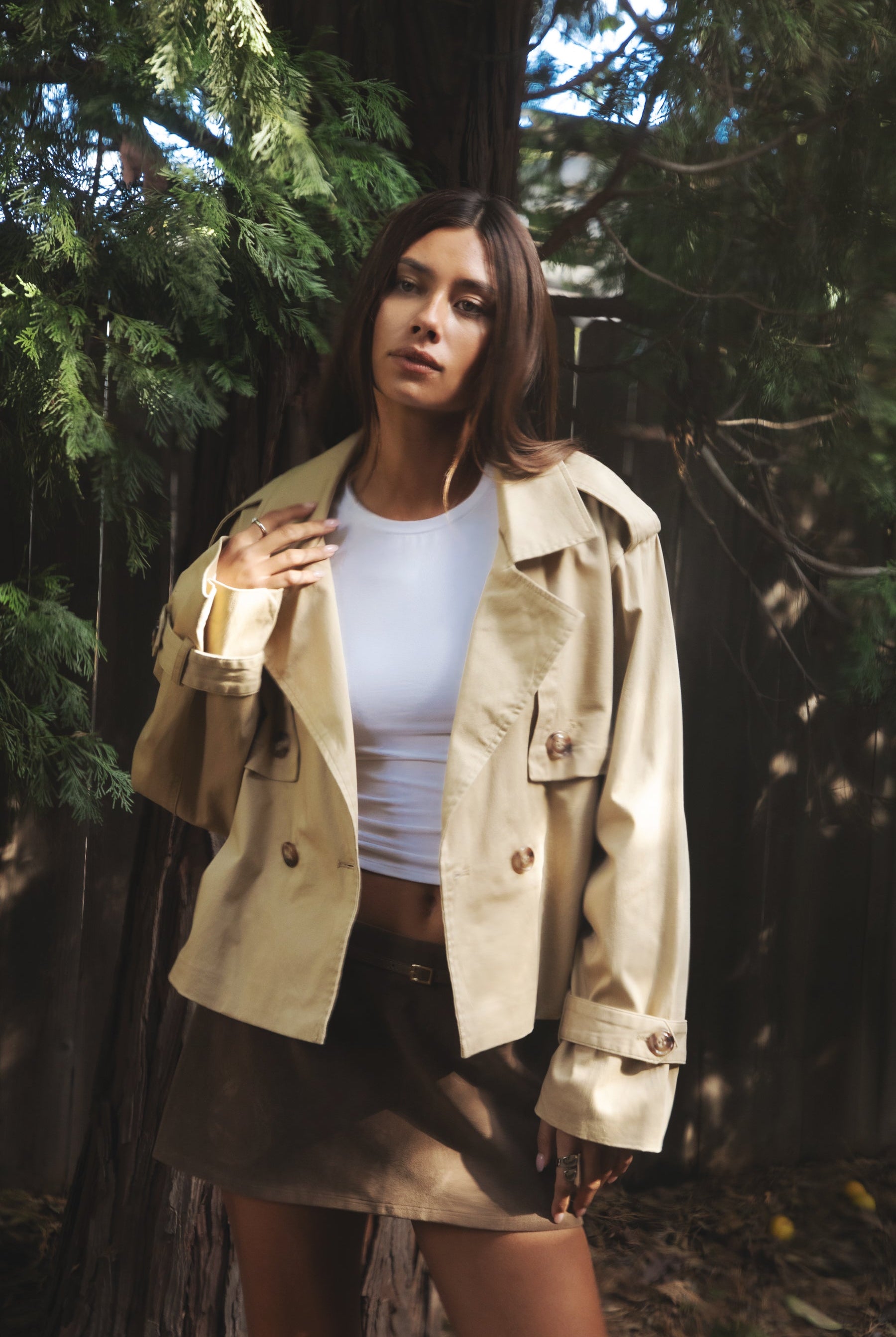 Woman wearing TIC TOC TT31828-MARAIS MARAIS oversized long sleeve cropped trench jacket featuring a double breasted front button closure, drop shoulder long sleeves with adjustable sleeve straps, removable thick self tie waist strap, and two loop holes on the back, finished with stripe voile lining inside, styled over a simple top and tailored bottoms for a Parisian chic, western-minimal layered look.