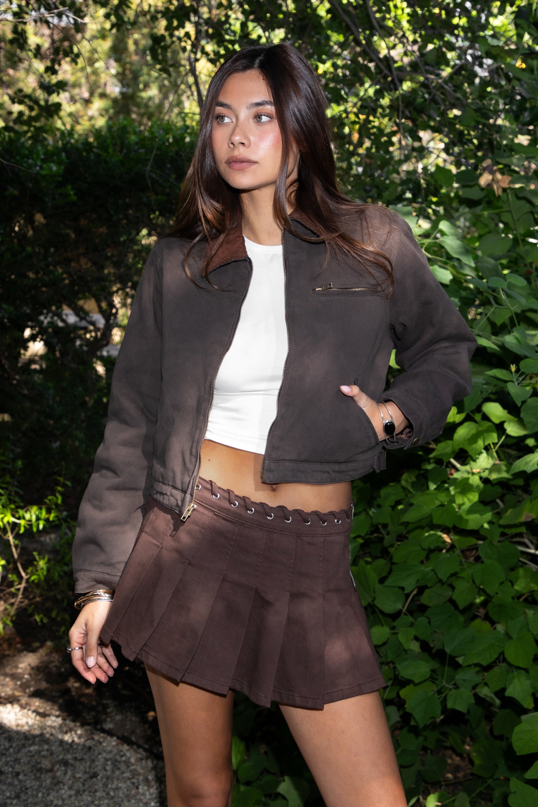 Woman wearing TIC TOC TT31861-FLINT FLINT washed solid twill cropped jacket featuring a front zip closure, contrast brown corduroy collar, two side pockets, a single chest zip pocket, snap button cuffs, and side buckle strap detail at the waistline, with satin quilted lining and light padding, styled over a simple top and denim for a western-inspired everyday transitional look.