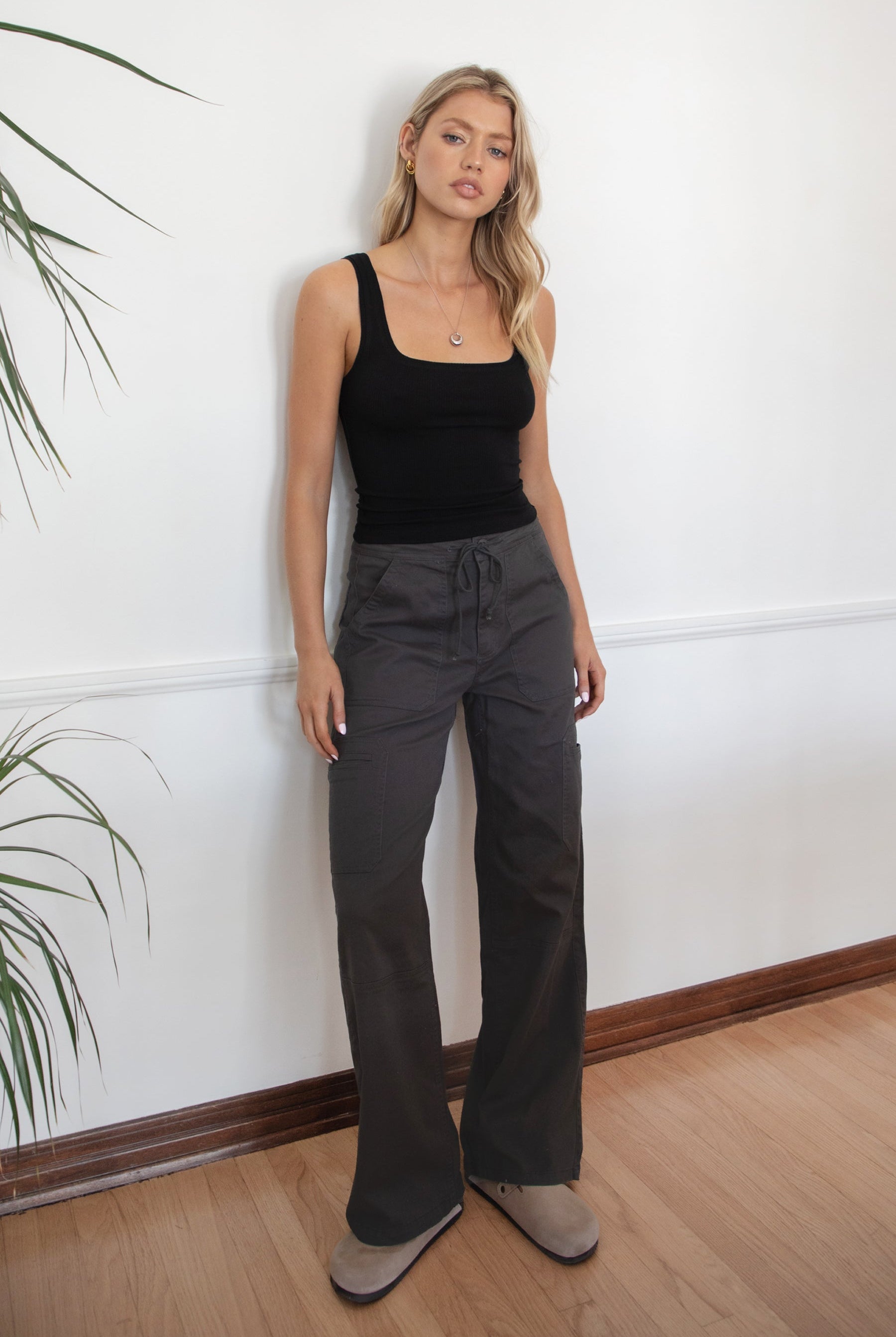 Woman wearing a black tank top and TIC TOC PH29257 ARROW charcoal twill carpenter cargo pants featuring multiple utility pockets and straight-leg fit.