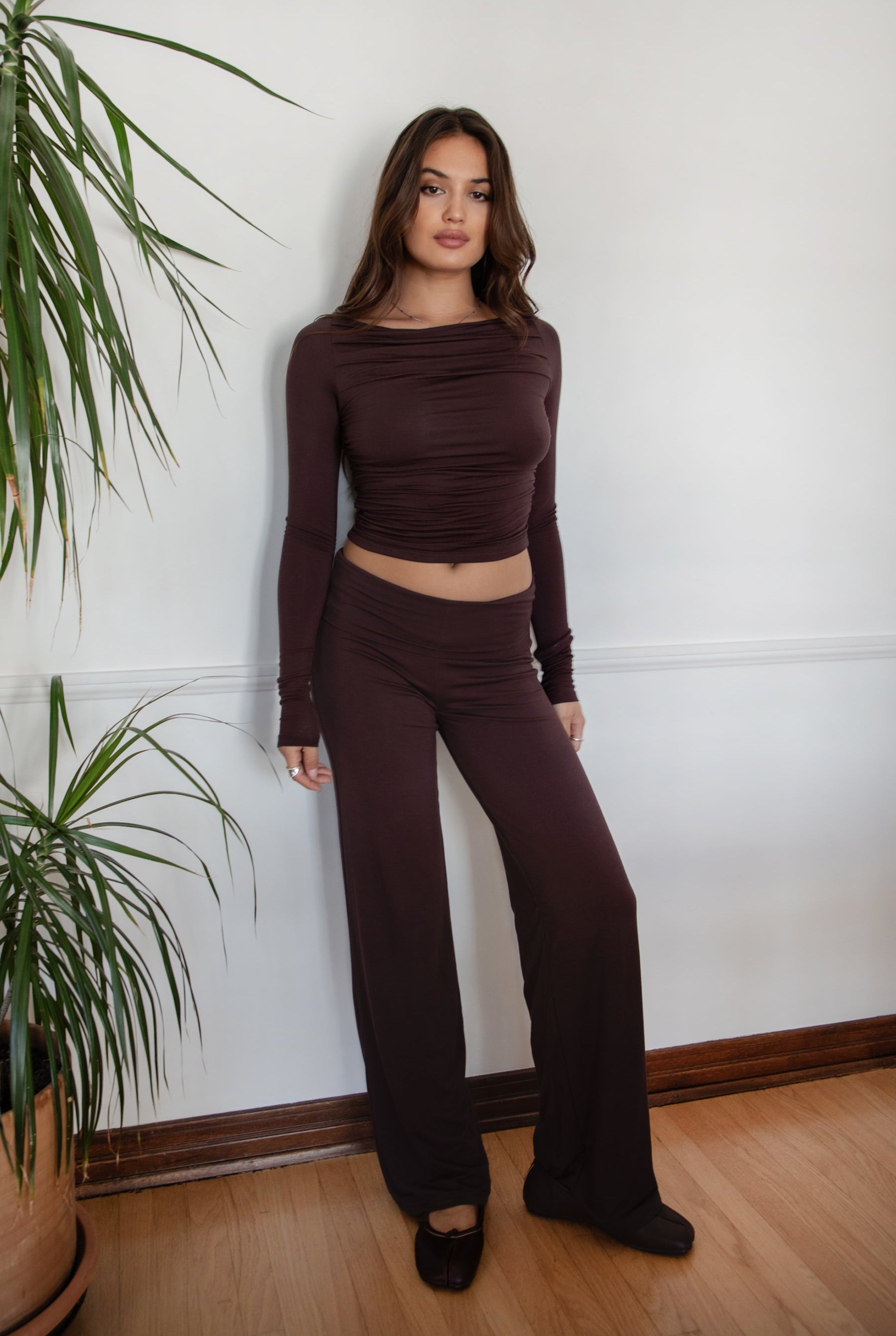 Woman wearing the TIC TOC PH31588BA SORA brown fold over straight leg leggings featuring a low rise waistline, smooth stretch fabric, and straight leg finish with the matching top against a white wall.