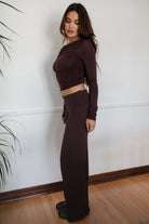 Woman wearing the TIC TOC PH31588BA SORA brown fold over straight leg leggings featuring a low rise waistline, smooth stretch fabric, and straight leg finish with the matching top against a white wall.