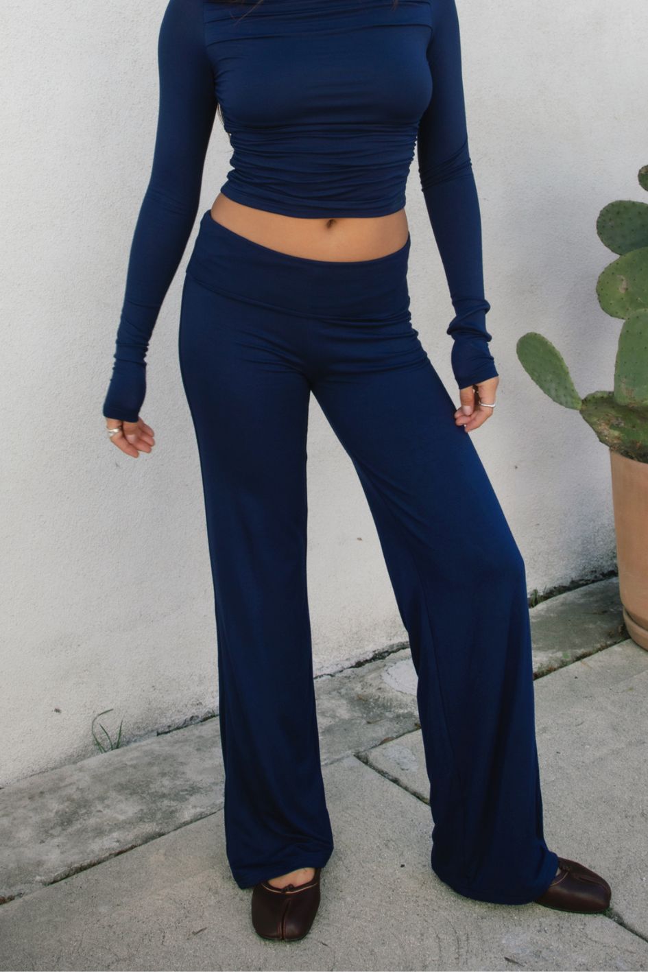 Woman wearing the TIC TOC PH31588BA SORA navy fold over straight leg leggings featuring a low rise waistline, smooth stretch fabric, and straight leg finish with the matching top outdoors.