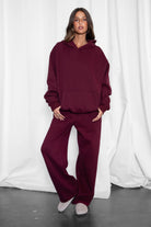 Woman wearing the TIC TOC PJ30241 LANI black cherry cloud fleece wide leg sweatpants featuring a straight leg silhouette, drawcord waistband, and side pockets paired with a matching sweater.