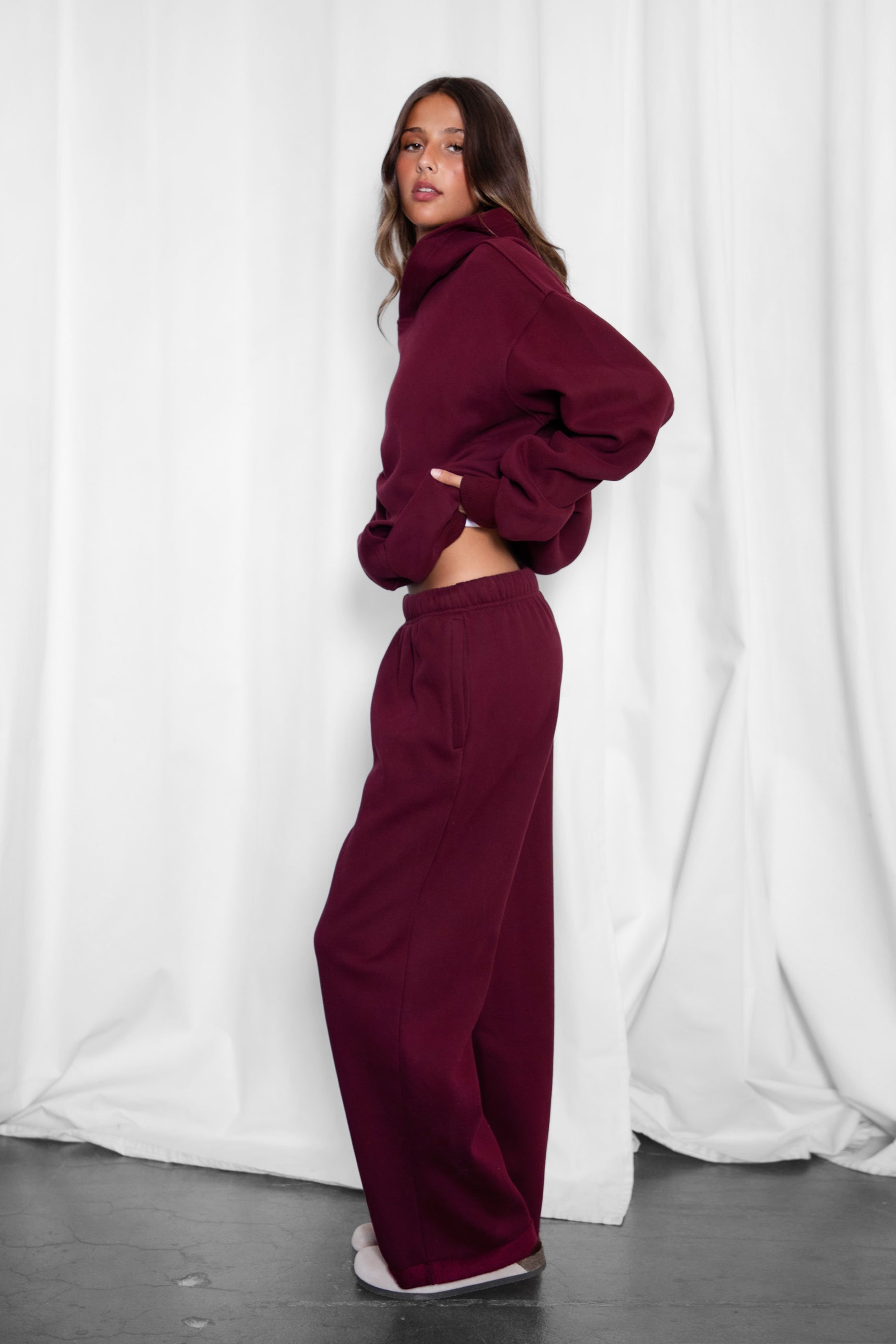 Woman wearing the TIC TOC PJ30241 LANI black cherry cloud fleece wide leg sweatpants featuring a straight leg silhouette, drawcord waistband, and side pockets paired with a matching sweater.