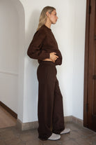 Woman wearing the TIC TOC PJ30241 LANI brown cloud fleece wide leg sweatpants featuring a straight leg silhouette, drawcord waistband, and side pockets paired with a matching hoodie.