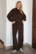 Woman wearing the TIC TOC PJ30241 LANI brown cloud fleece wide leg sweatpants featuring a straight leg silhouette, drawcord waistband, and side pockets paired with a matching hoodie.