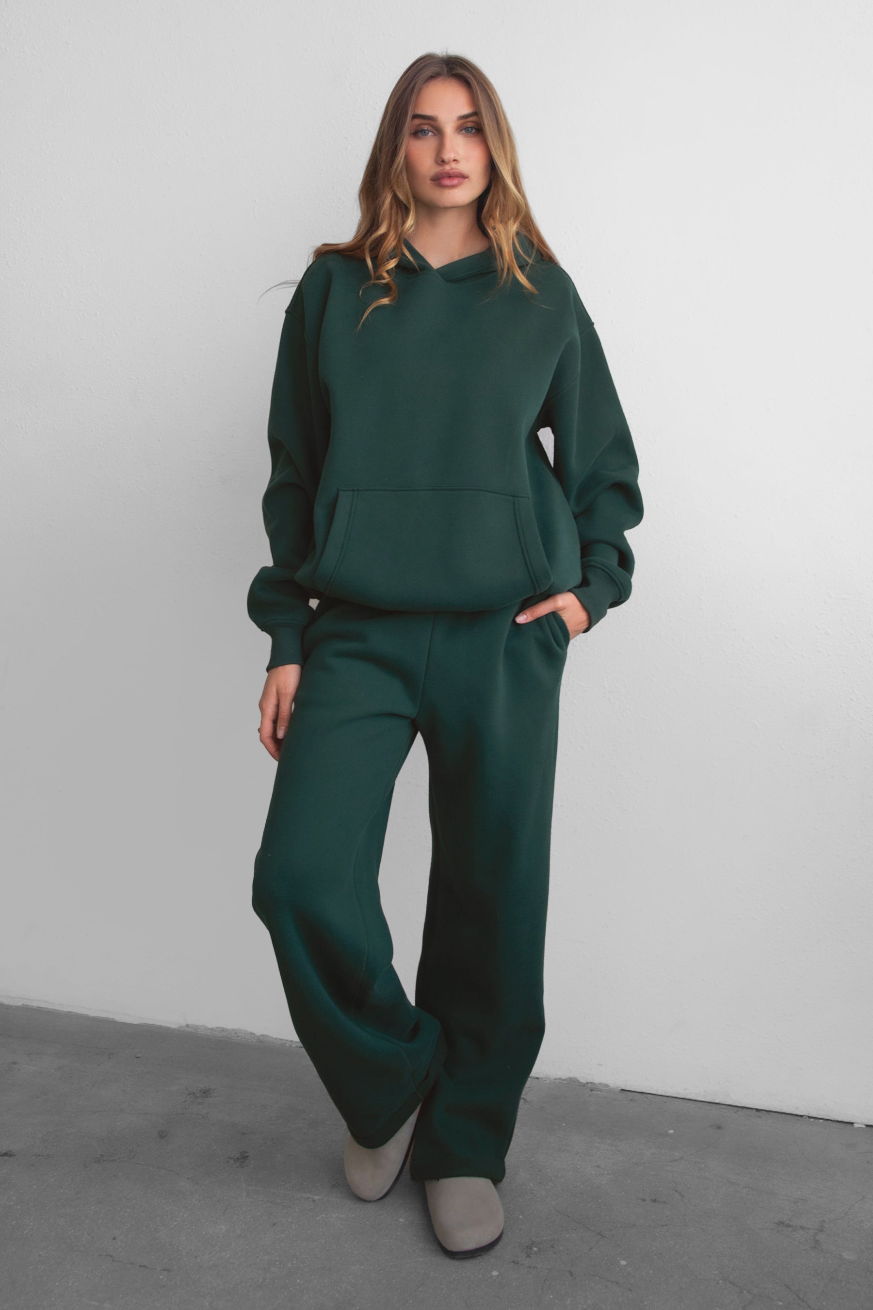 Woman wearing the TIC TOC PJ30241 LANI forrest green cloud fleece wide leg sweatpants featuring a straight leg silhouette, drawcord waistband, and side pockets paired with a matching sweater.