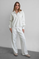 Woman wearing the TIC TOC PJ30241 LANI heather white cloud fleece wide leg sweatpants featuring a straight leg silhouette, drawcord waistband, and side pockets paired with a matching sweater.