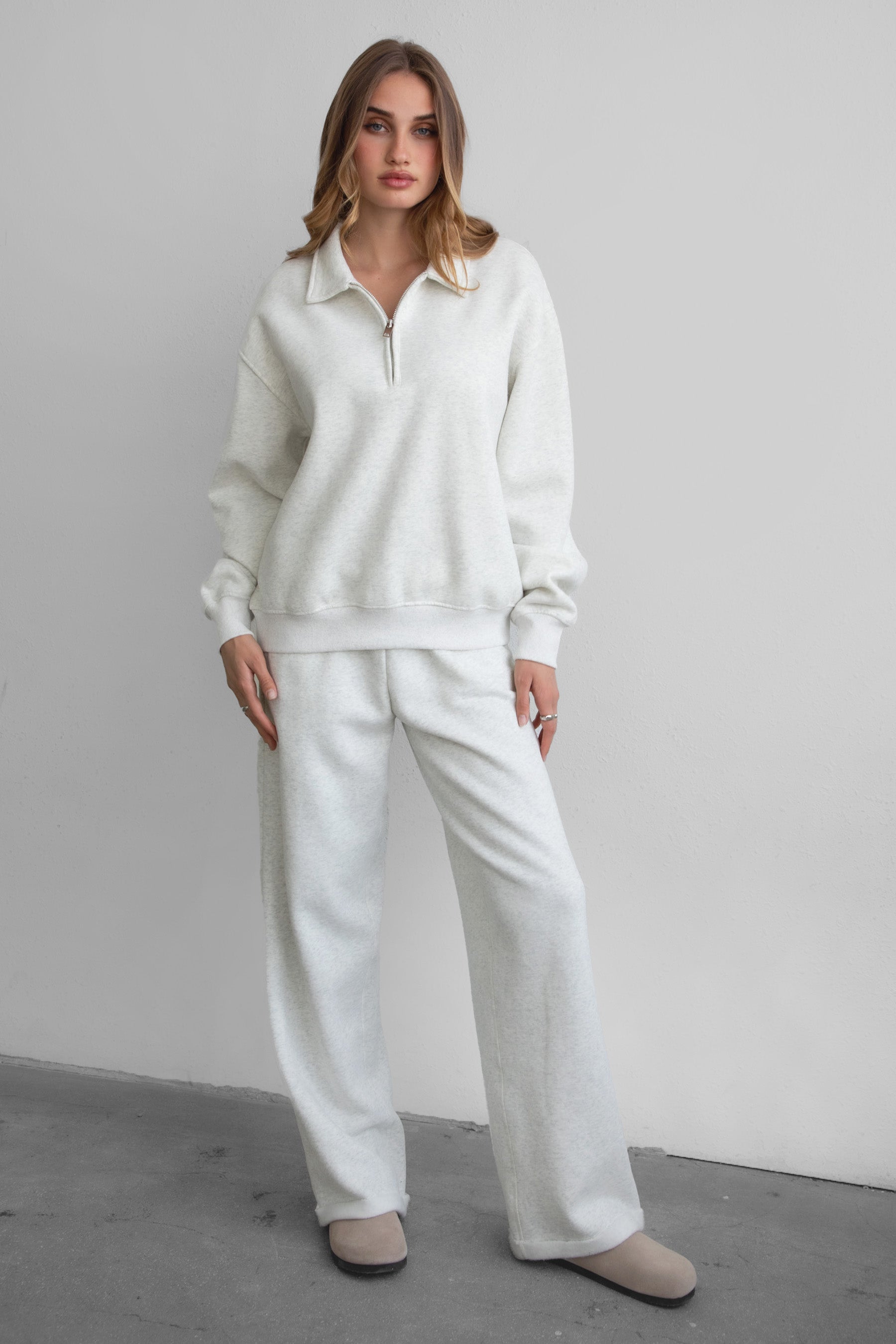 Woman wearing the TIC TOC PJ30241 LANI heather white cloud fleece wide leg sweatpants featuring a straight leg silhouette, drawcord waistband, and side pockets paired with a matching sweater.