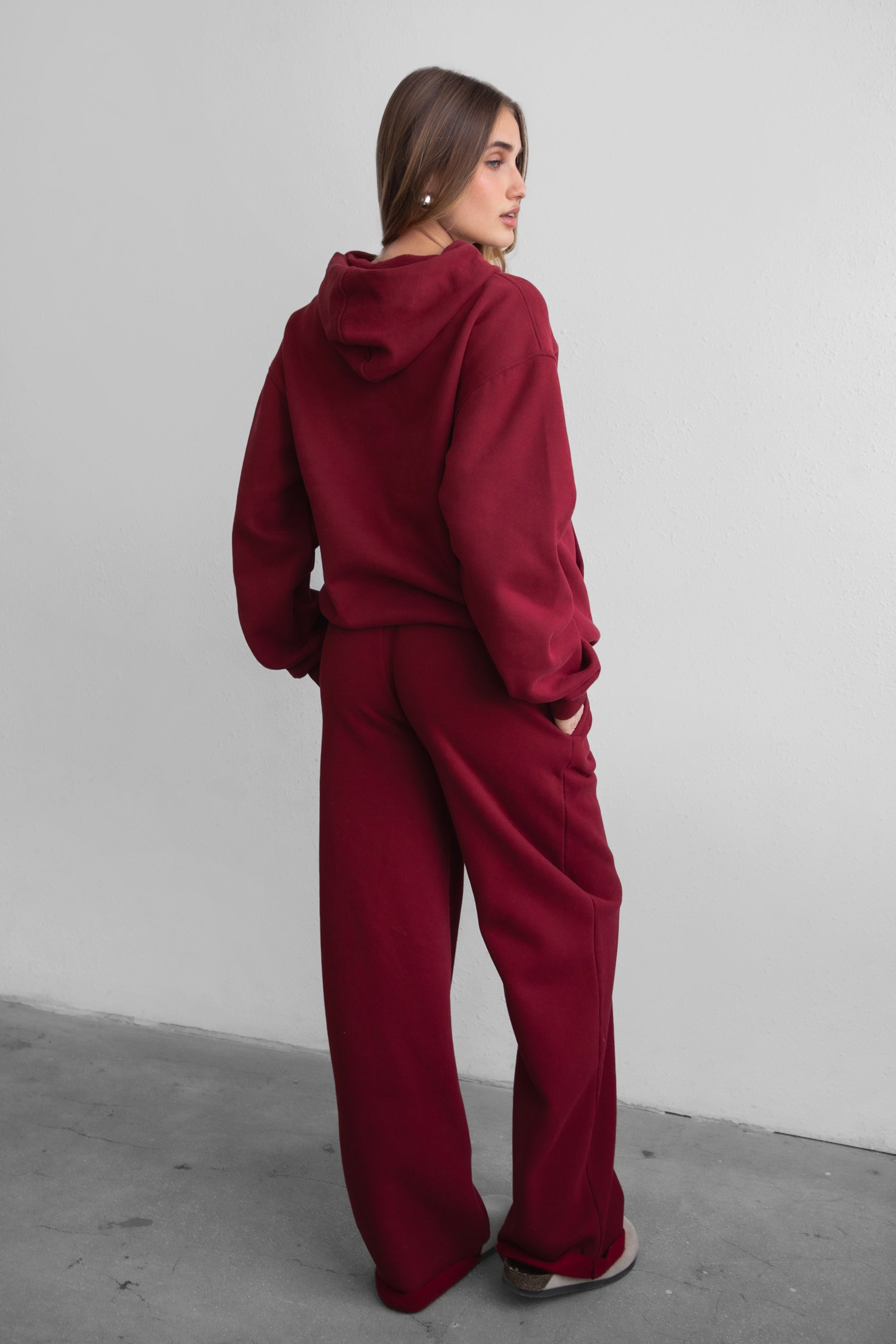 Woman wearing the TIC TOC PJ30241 LANI maroon cloud fleece wide leg sweatpants featuring a straight leg silhouette, drawcord waistband, and side pockets paired with a matching sweater.