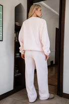 Woman wearing the TIC TOC PJ30241 LANI pale pink cloud fleece wide leg sweatpants featuring a straight leg silhouette, drawcord waistband, and side pockets paired with a matching sweater.