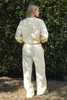 Woman wearing the TIC TOC PJ30241 LANI pale yellow cloud fleece wide leg sweatpants featuring a straight leg silhouette, drawcord waistband, and side pockets paired with a matching sweater.