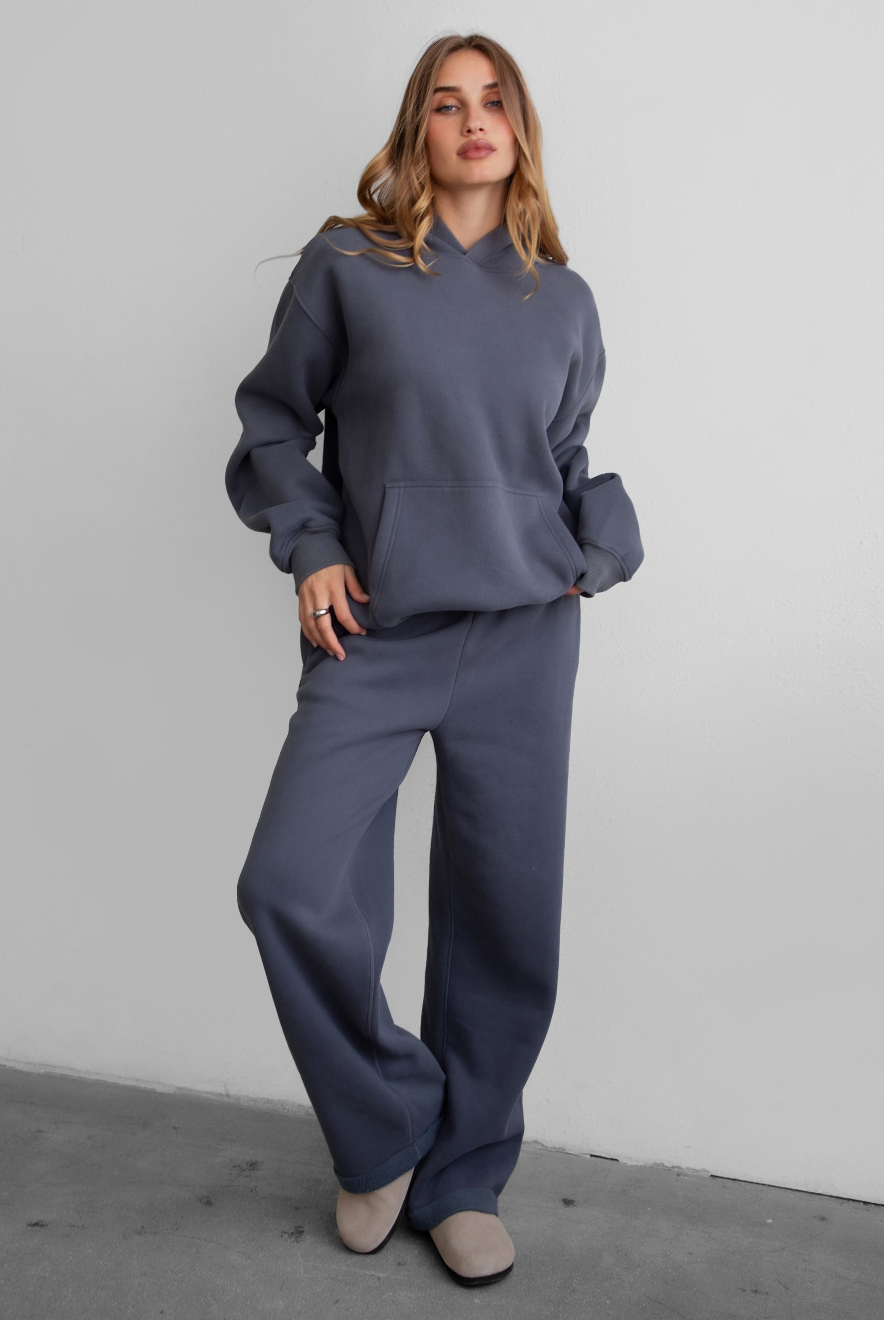 Woman wearing the TIC TOC PJ30241 LANI steel grey cloud fleece wide leg sweatpants featuring a straight leg silhouette, drawcord waistband, and side pockets paired with a matching sweater.