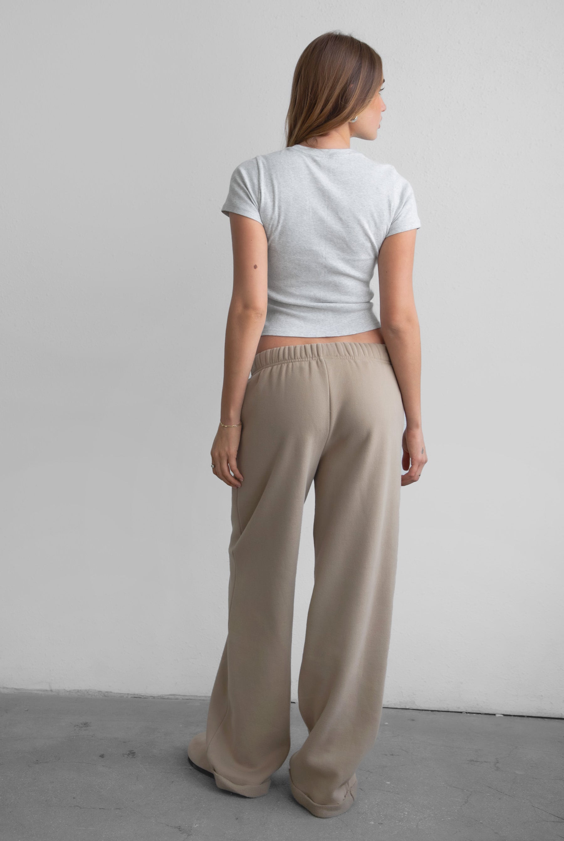 Woman wearing the TIC TOC PJ30241 LANI taupe cloud fleece wide leg sweatpants featuring a straight leg silhouette, drawcord waistband, and side pockets paired with a baby tee.