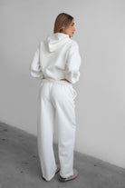 Woman wearing the TIC TOC PJ30241 LANI white cloud fleece wide leg sweatpants featuring a straight leg silhouette, drawcord waistband, and side pockets paired with a matching sweater.