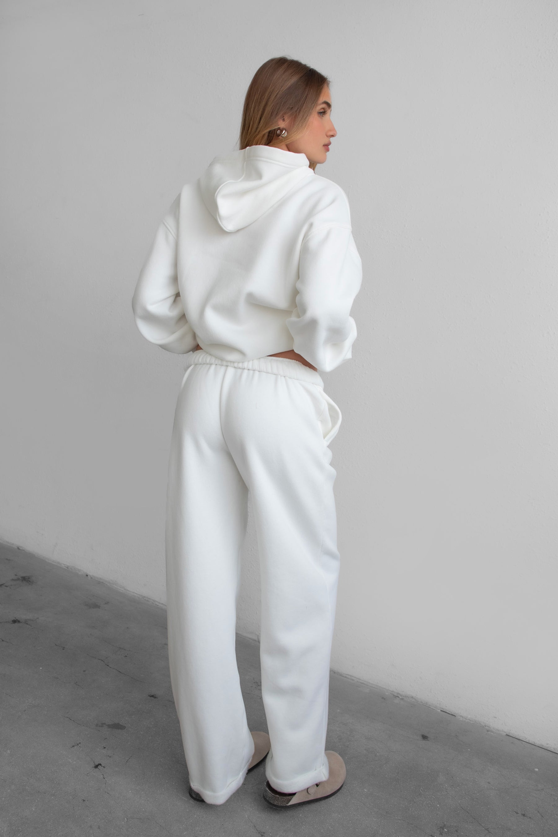 Woman wearing the TIC TOC PJ30241 LANI white cloud fleece wide leg sweatpants featuring a straight leg silhouette, drawcord waistband, and side pockets paired with a matching sweater.