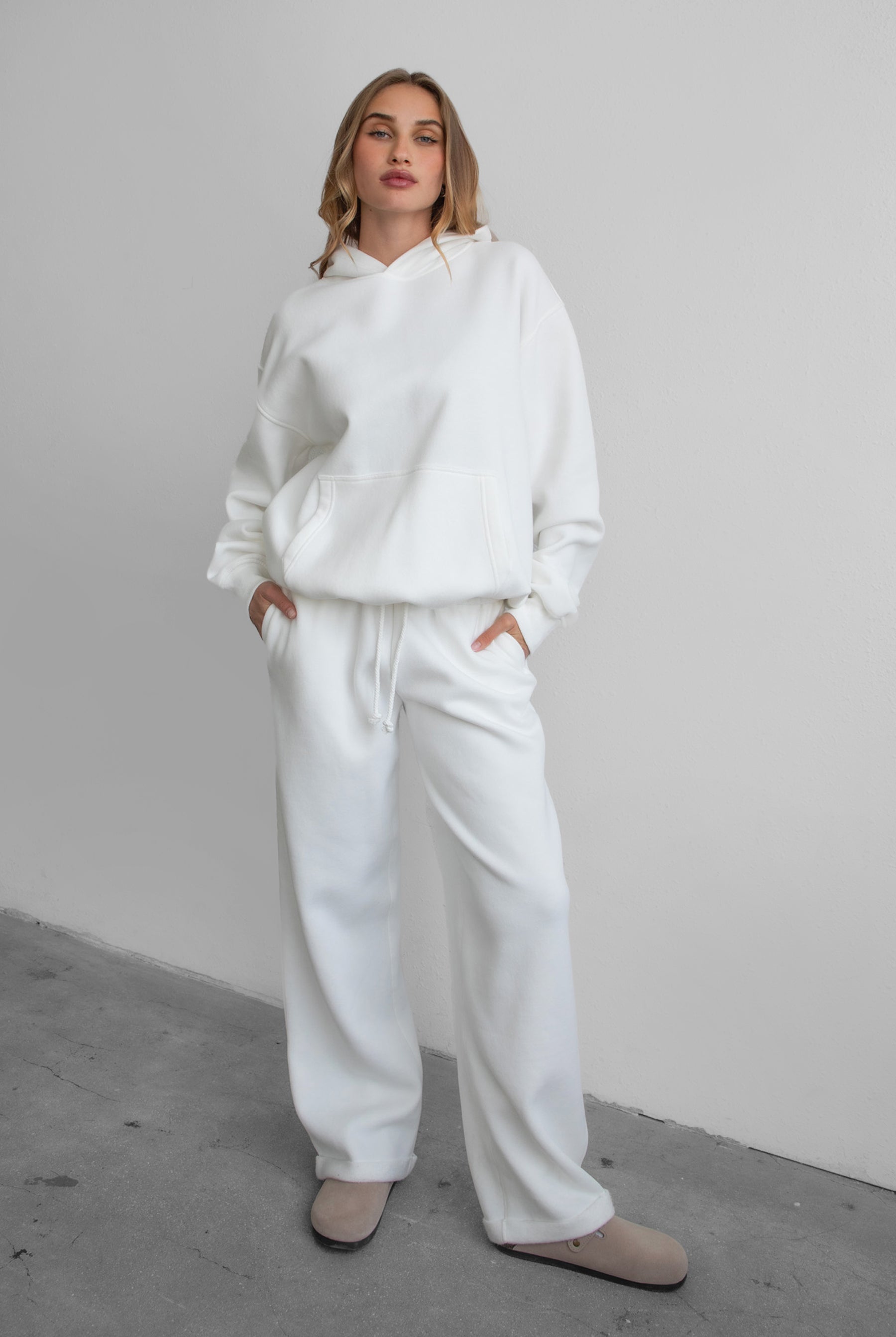 Woman wearing the TIC TOC PJ30241 LANI white cloud fleece wide leg sweatpants featuring a straight leg silhouette, drawcord waistband, and side pockets paired with a matching sweater.