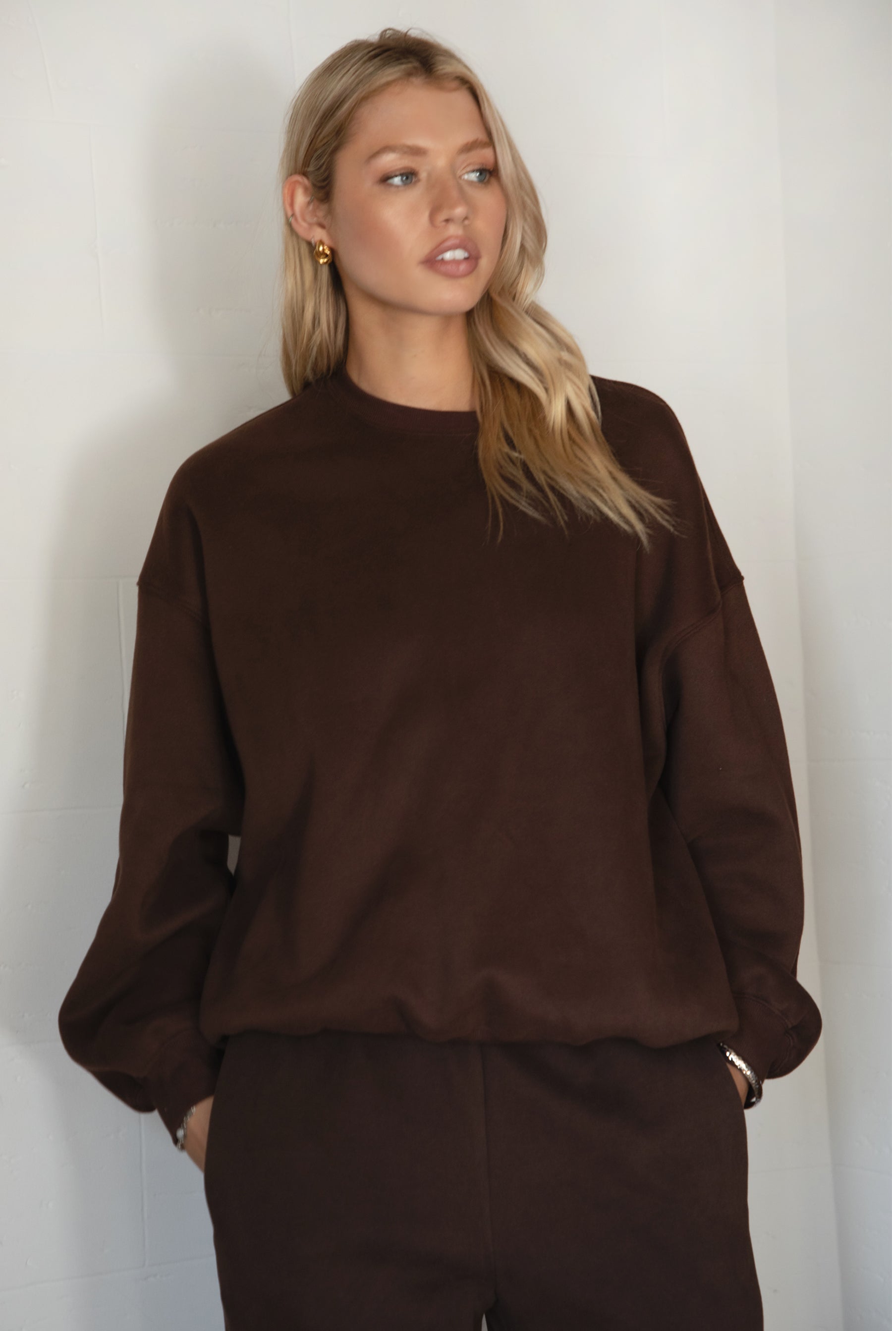 Woman wearing a brown sweater against a white background
