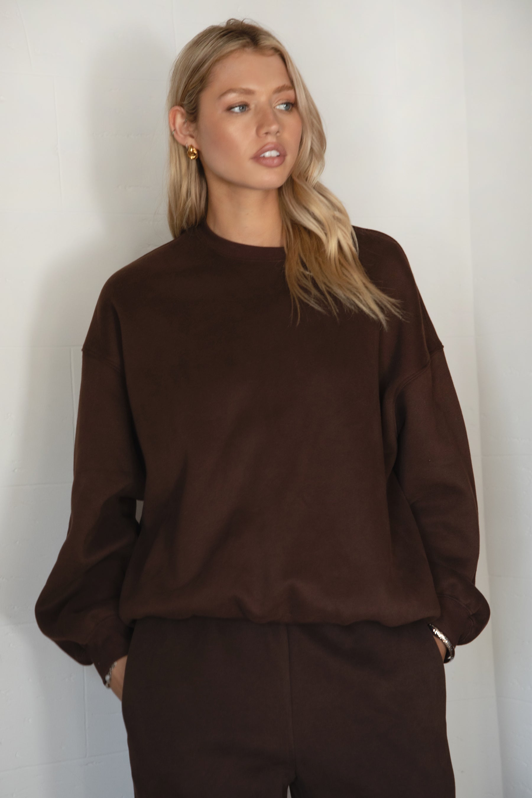Woman wearing a brown sweater against a white background