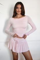 Woman wearing the TIC TOC TH30643 JOLINA blush core basic long sleeve top featuring high boat neckline, thumbhole sleeves, and ruched detailing along the bodice with matching bottoms in an indoor setting.