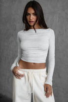 Woman wearing the TIC TOC TH30643 JOLINA heather white core basic long sleeve top featuring high boat neckline,  and ruched detailing along the bodice with matching bottoms.