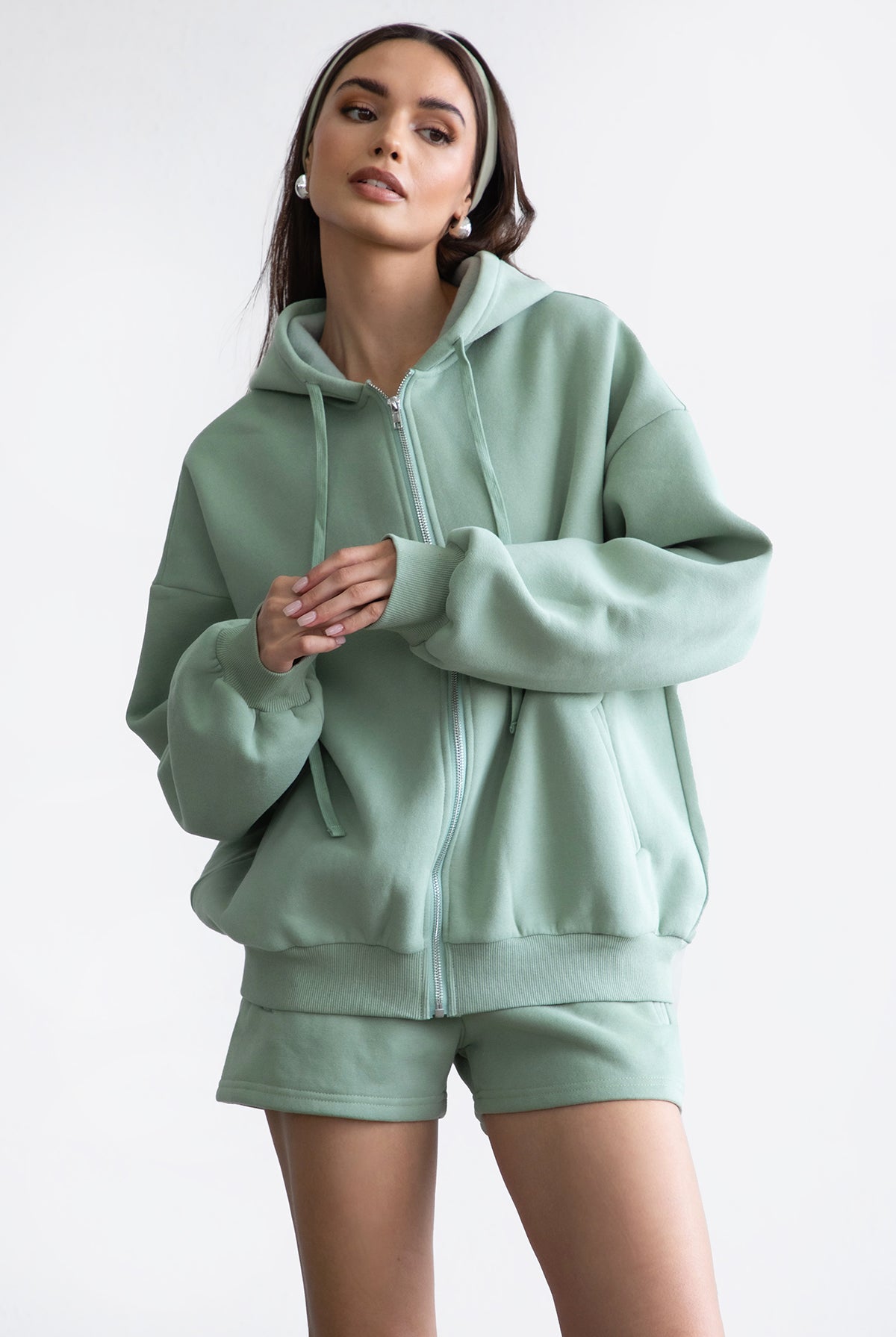 Sage green oversized zip-up hoodie featuring a functional zipper and a smooth, soft fleece texture by Tic Toc.