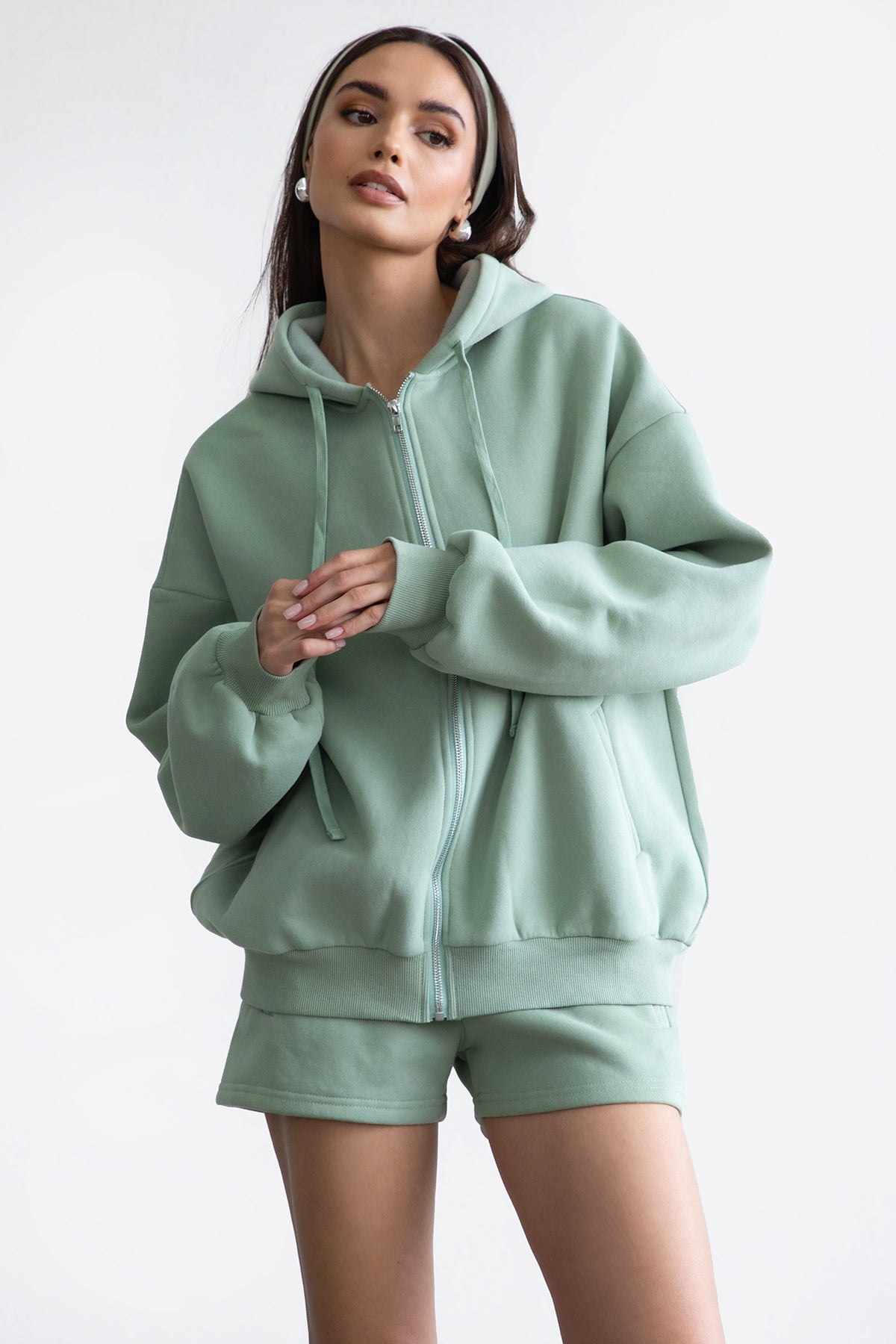 Sage green oversized zip-up hoodie featuring a functional zipper and a smooth, soft fleece texture by Tic Toc.