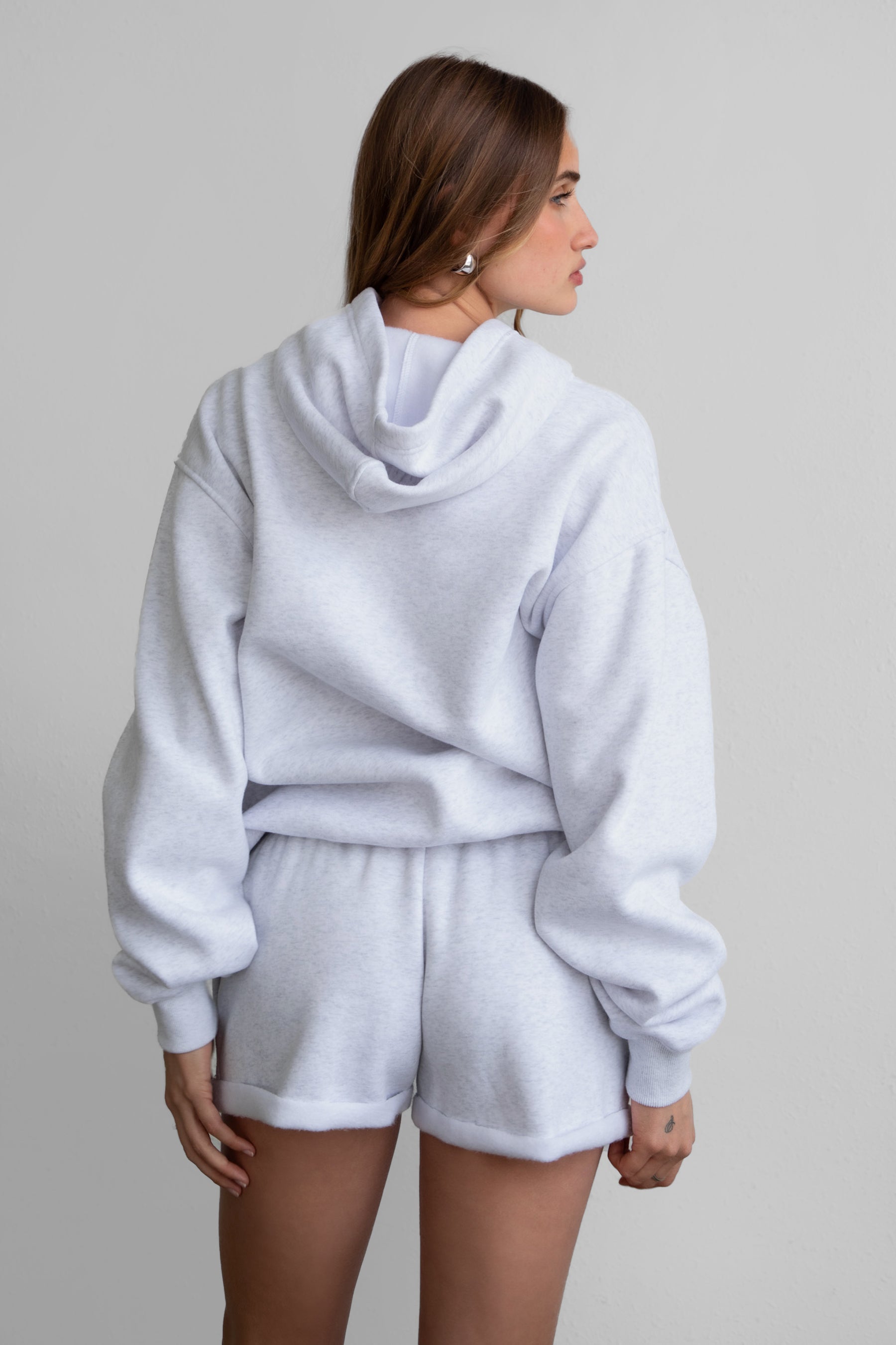 Woman wearing the TIC TOC TJ31007 DAMI ash cloud fleece oversized hoodie featuring a dropped shoulder design, kangaroo pocket, and ribbed cuffs with matching bottoms.