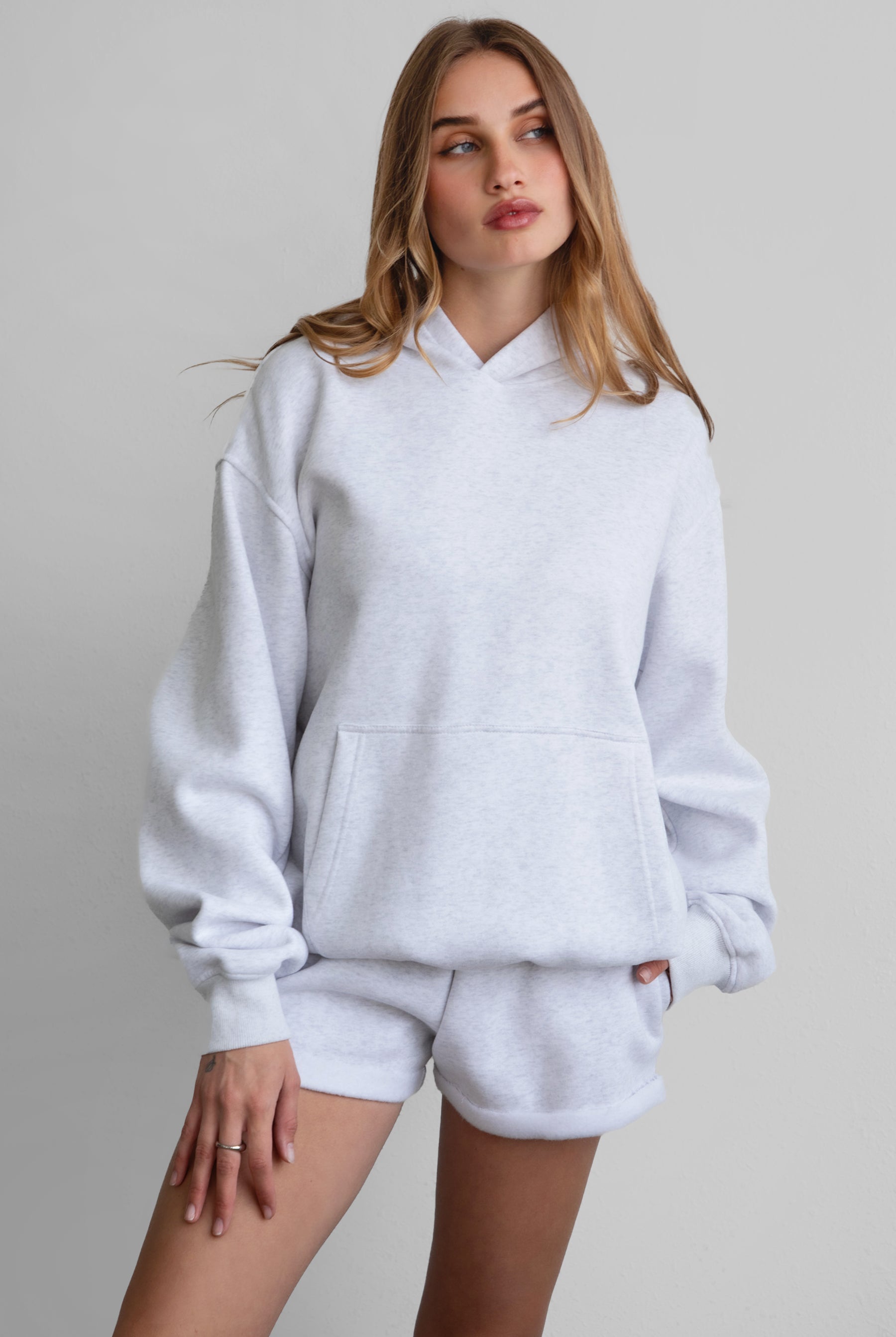 Woman wearing the TIC TOC TJ31007 DAMI ash cloud fleece oversized hoodie featuring a dropped shoulder design, kangaroo pocket, and ribbed cuffs with matching bottoms.