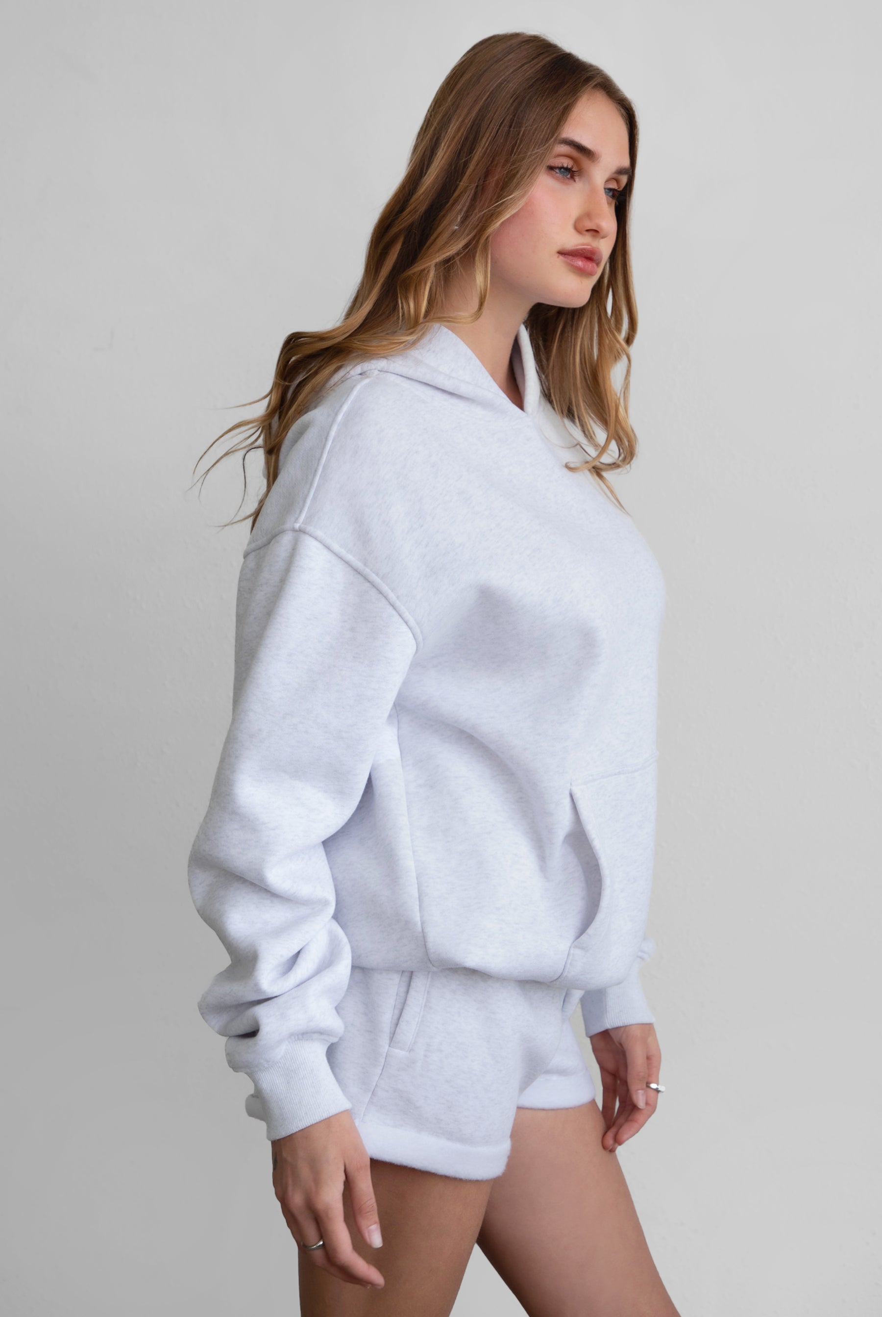 Woman wearing the TIC TOC TJ31007 DAMI ash cloud fleece oversized hoodie featuring a dropped shoulder design, kangaroo pocket, and ribbed cuffs with matching bottoms.