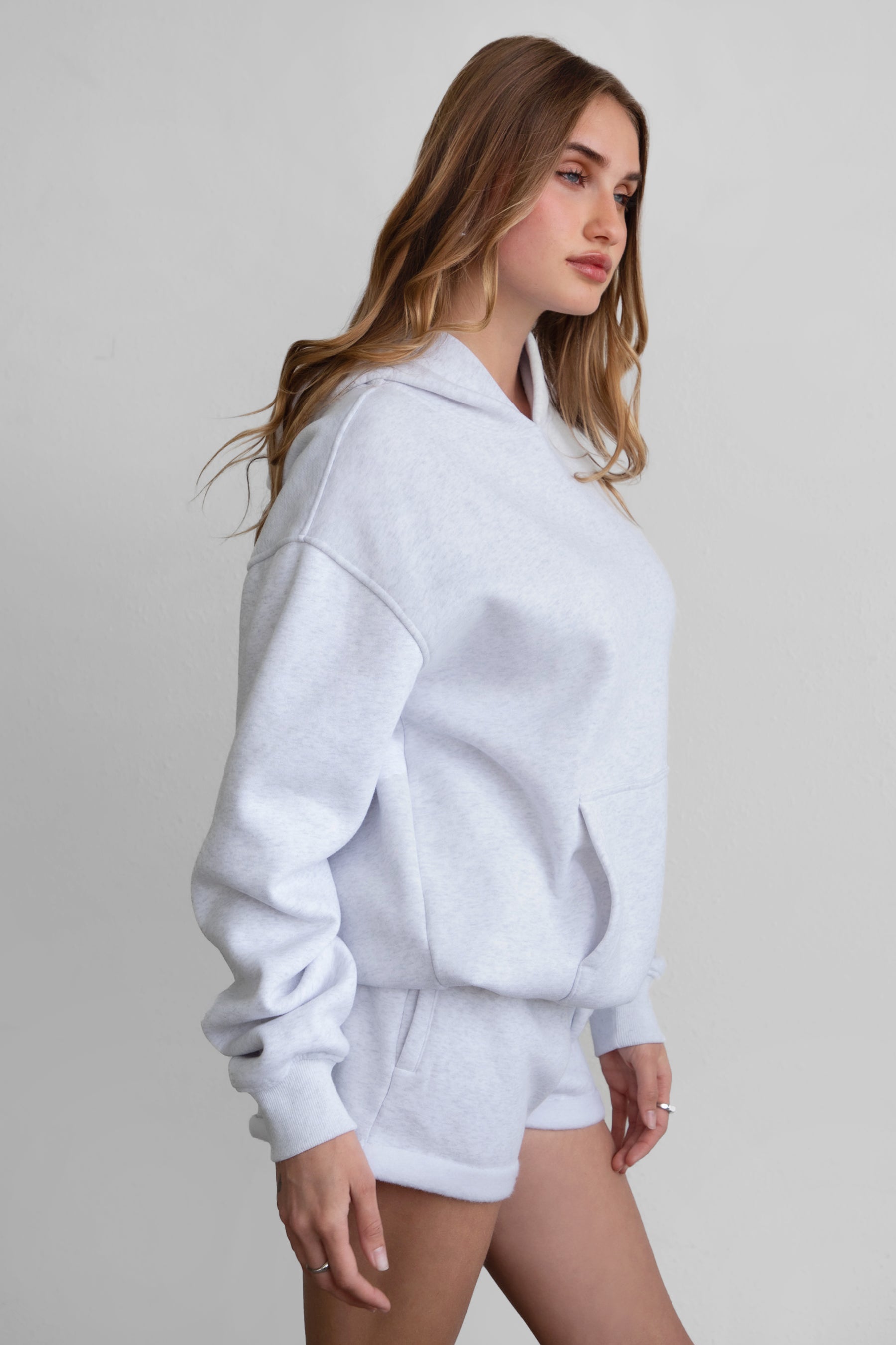 Woman wearing the TIC TOC TJ31007 DAMI ash cloud fleece oversized hoodie featuring a dropped shoulder design, kangaroo pocket, and ribbed cuffs with matching bottoms.