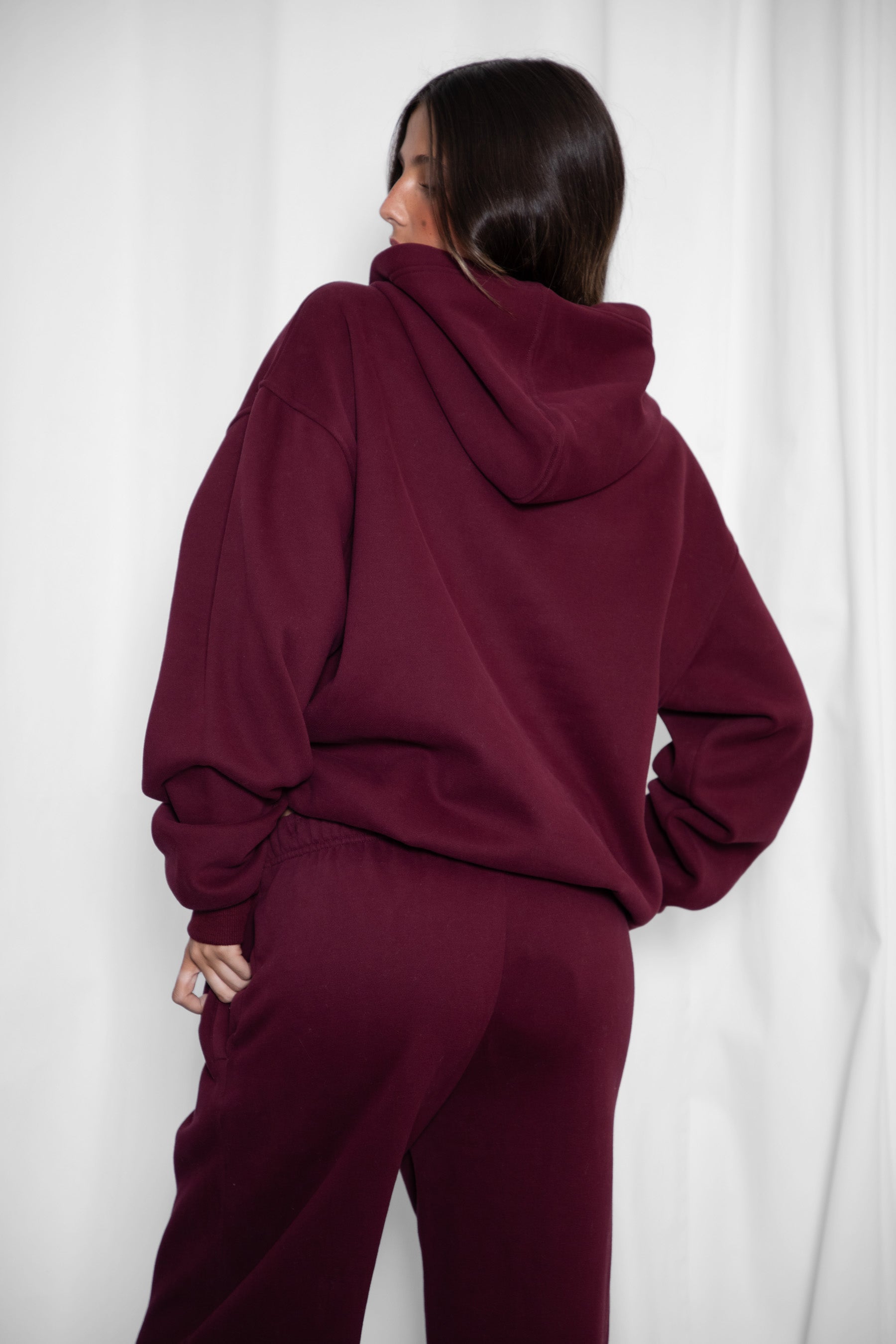 Woman wearing the TIC TOC TJ31007 DAMI black cherry cloud fleece oversized hoodie featuring a dropped shoulder design, kangaroo pocket, and ribbed cuffs with matching bottoms.