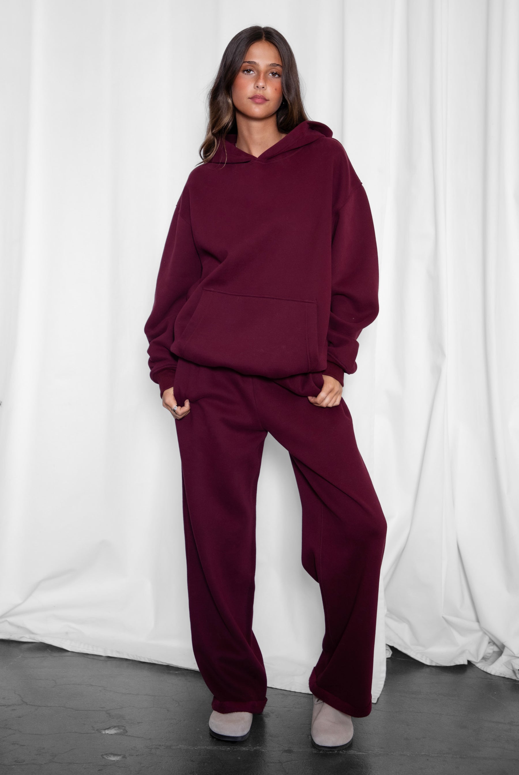 Woman wearing the TIC TOC TJ31007 DAMI black cherry cloud fleece oversized hoodie featuring a dropped shoulder design, kangaroo pocket, and ribbed cuffs with matching bottoms.