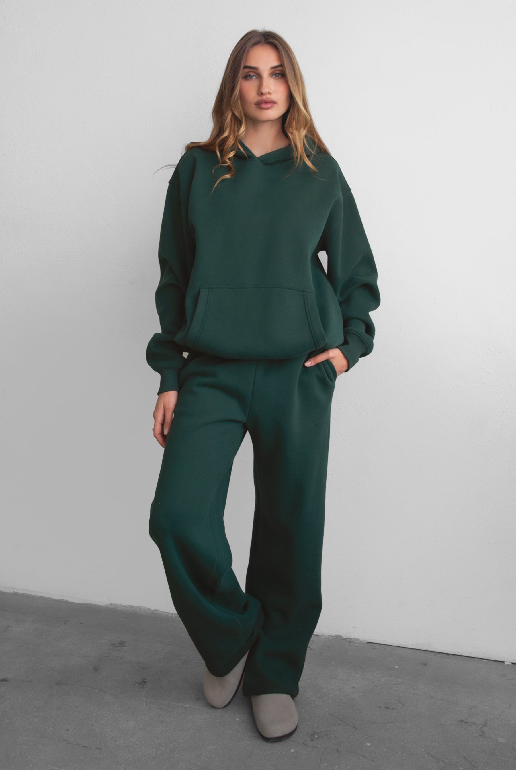 Woman wearing the TIC TOC TJ31007 DAMI forrest green cloud fleece oversized hoodie featuring a dropped shoulder design, kangaroo pocket, and ribbed cuffs with matching bottoms.