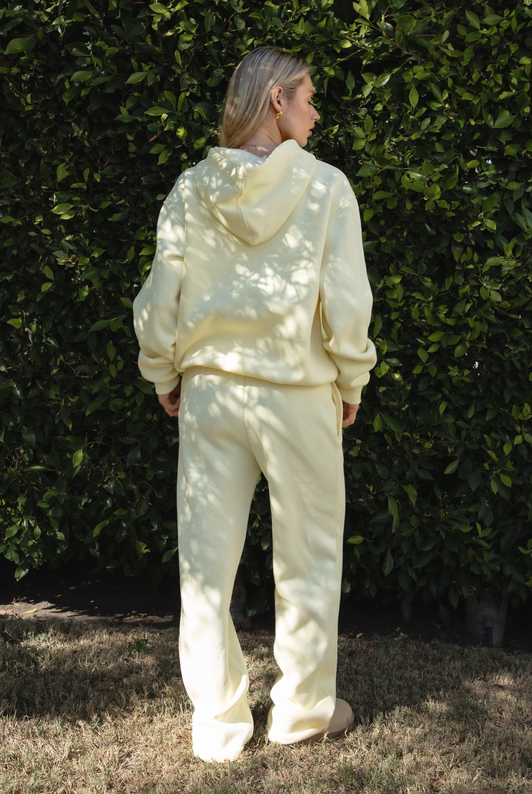 Woman wearing the TIC TOC TJ31007 DAMI pale yellow cloud fleece oversized hoodie featuring a dropped shoulder design, kangaroo pocket, and ribbed cuffs with matching bottoms.
