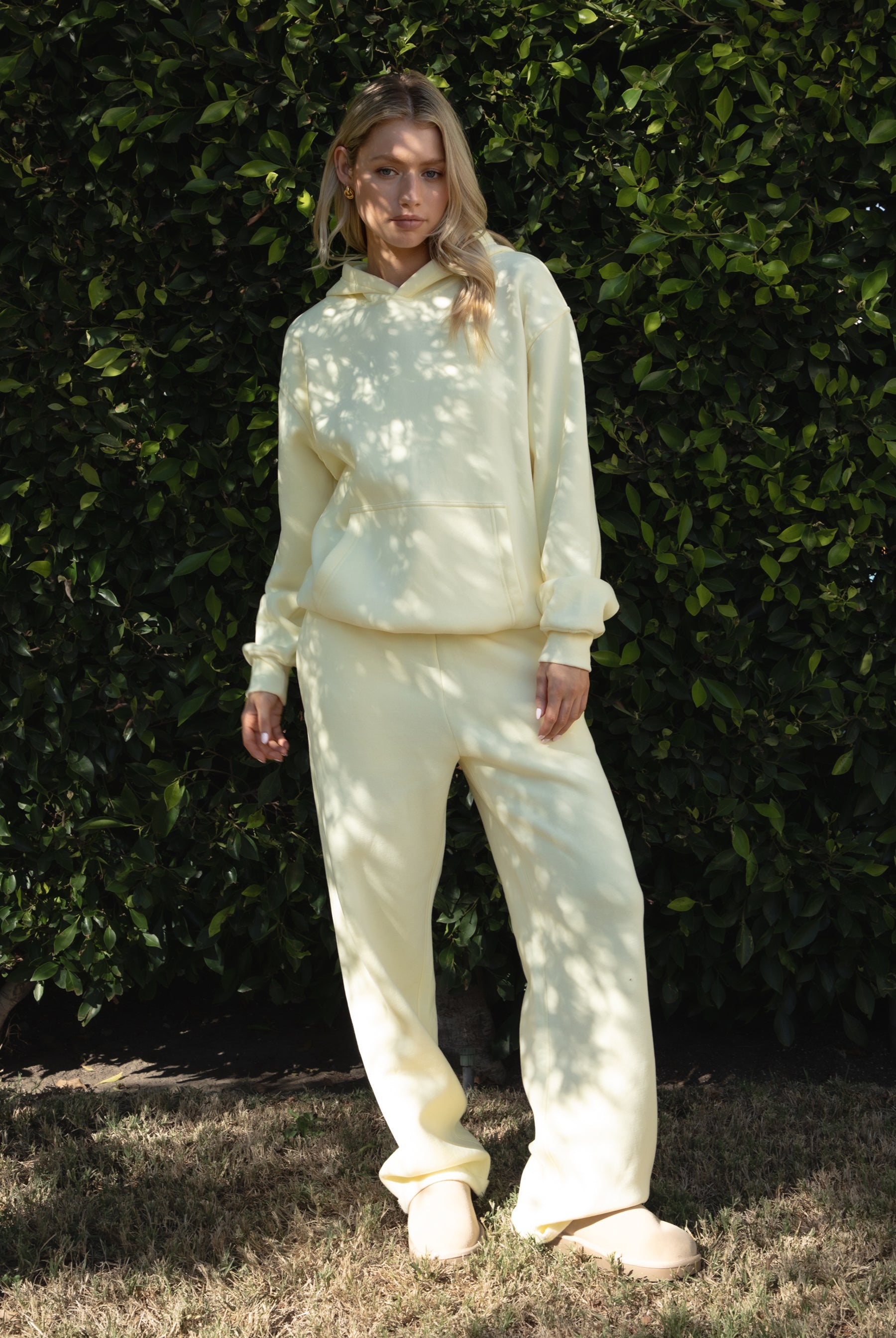 Woman wearing the TIC TOC TJ31007 DAMI pale yellow cloud fleece oversized hoodie featuring a dropped shoulder design, kangaroo pocket, and ribbed cuffs with matching bottoms.