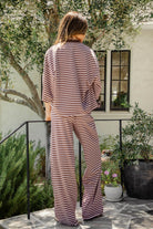 Woman wearing MARLOWE stretch mid waist stripe wide leg pants featuring an allover stripe pattern, adjustable drawstring waist, relaxed wide leg silhouette, full length fit, and soft stretch jersey fabric for cozy casual lounge styling.