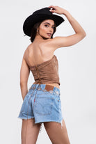 Woman wearing TIC TOC TA29069-BECKEE BECKEE embroidered western corset top featuring a strapless straight neckline, boned panel construction, dual lined PU vegan leather body, and rope lace-up detail at the center back, styled with high-waisted denim for a bold rodeo-ready western going-out look.