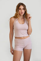 Woman wearing TIC TOC TPC30877-DEVONA striped jersey two piece lounge short set featuring a low V halter neckline with fixed strap and open back, paired with matching mid rise micro mini shorts with an elasticated waistband, styled indoors in a relaxed casual setting.
