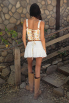 Woman wearing TIC TOC SA31409 YNES crinkle gauze tiered mini skort with built-in shorts, featuring a soft stretch smocked waist, easy pull-on fit, and airy semi-sheer gauze fabric for a boho spring and summer vacation look.