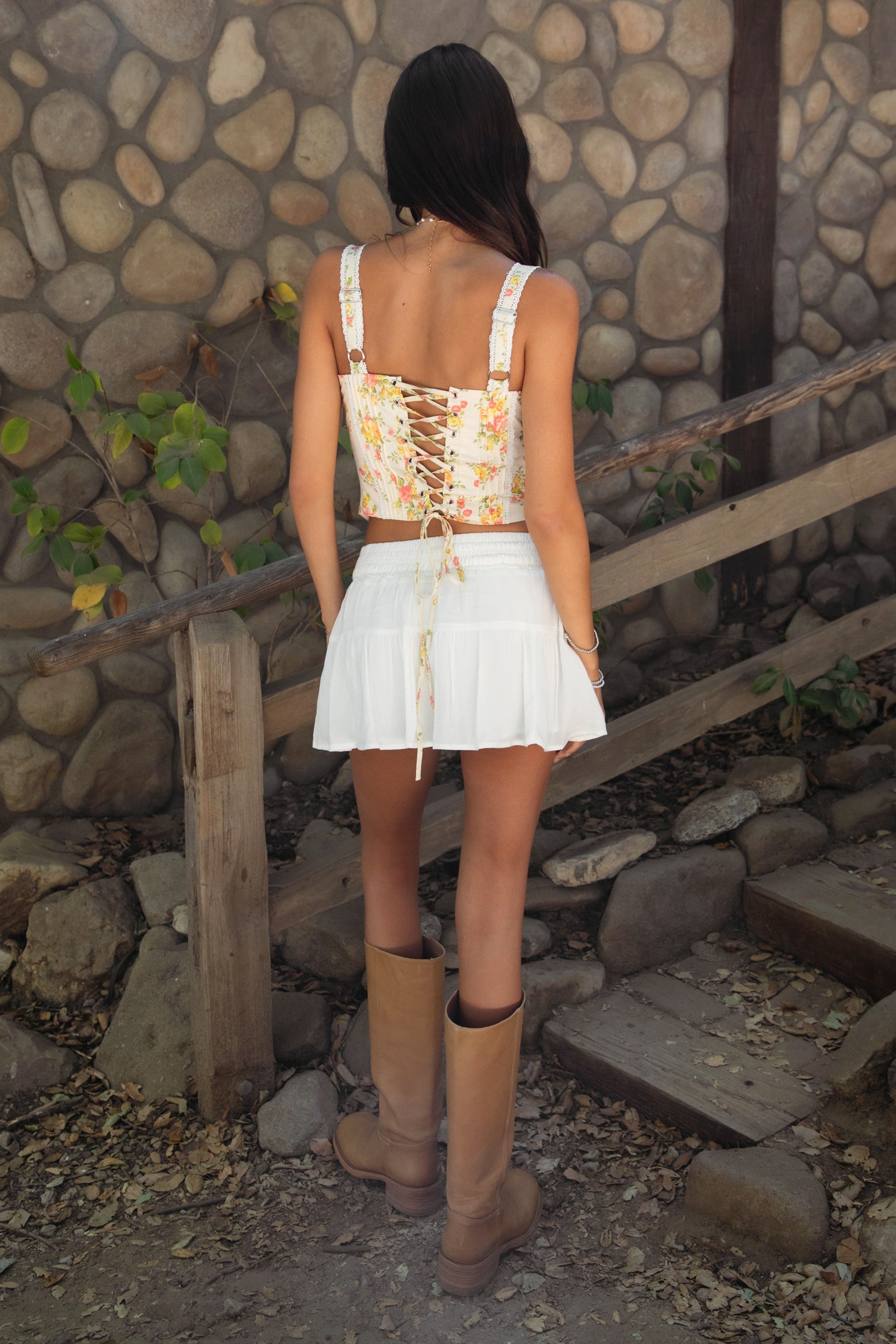 Woman wearing TIC TOC SA31409 YNES crinkle gauze tiered mini skort with built-in shorts, featuring a soft stretch smocked waist, easy pull-on fit, and airy semi-sheer gauze fabric for a boho spring and summer vacation look.