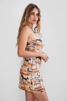 Woman wearing a strapless dress with horse print on a plain background