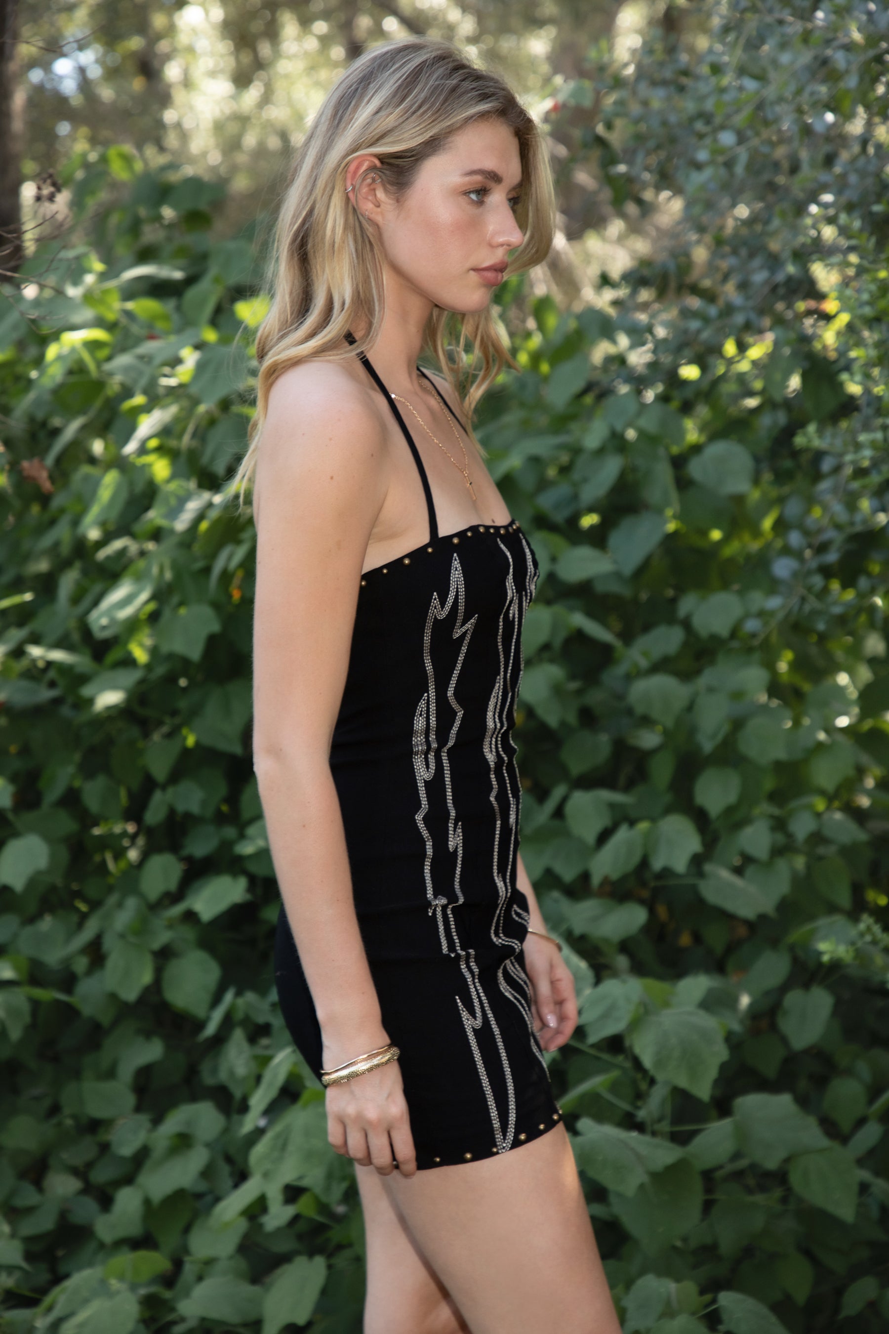 Woman wearing TIC TOC DA32063 ELSIE stretch embroidered western mini halter dress featuring a sculpted body-hugging fit, statement western-inspired embroidery, studded trim along the neckline and hem, halter self-tie closure, and mini length silhouette for a confident western-chic night-out look.