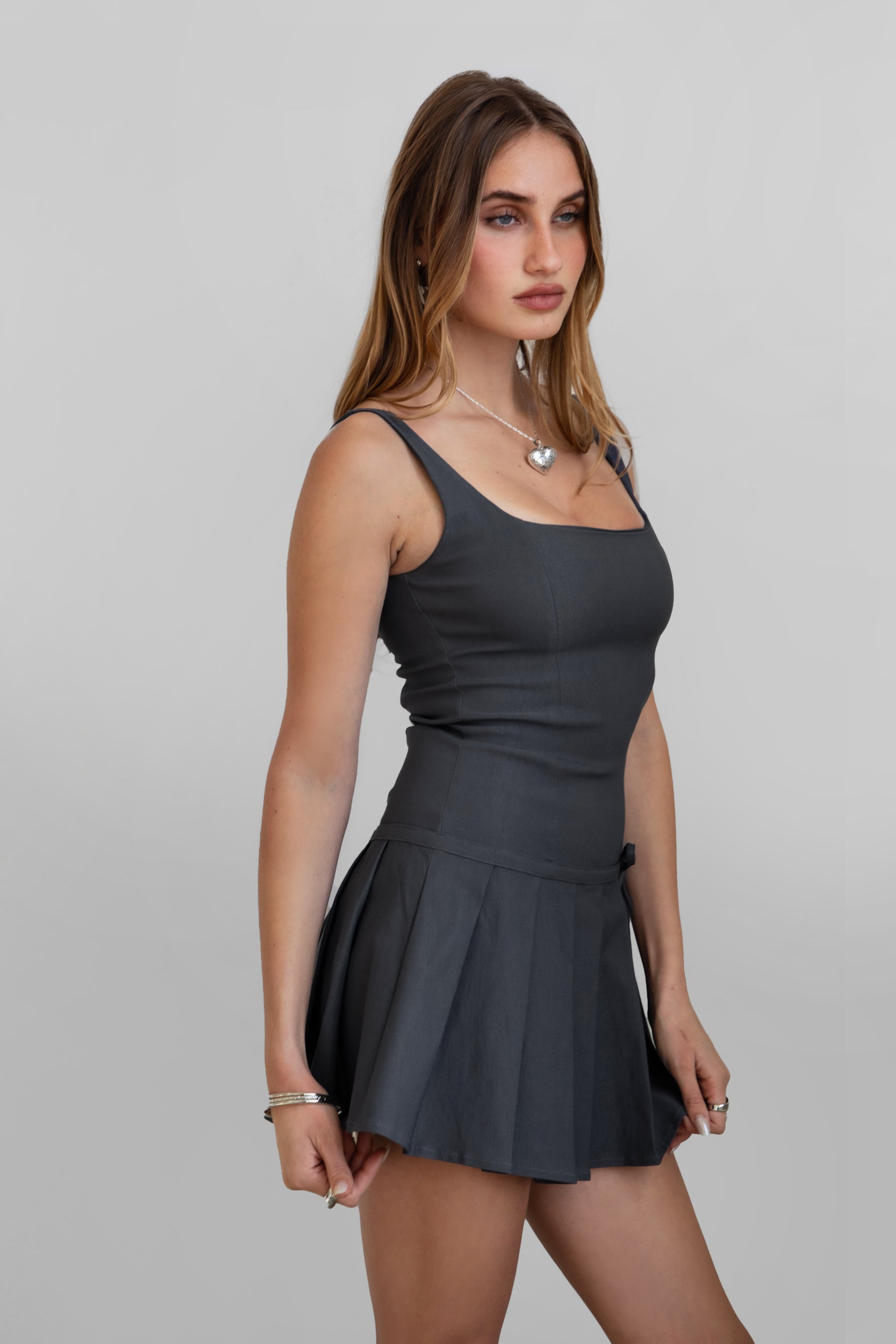 DC30797-ADRINA Drop Waist Mini Dress is flirty, fitted, and made to stand out. Featuring a square neckline with supportive fixed straps, this dress hugs the body through the waist and flares into a pleated mini skirt with a playful bow detail. Finished with a hidden back zipper and crafted from stretch millennium fabric for a smooth, sculpted fit—perfect for nights out, date plans, or any moment worth dressing up.

Stretch Millennium Fabric