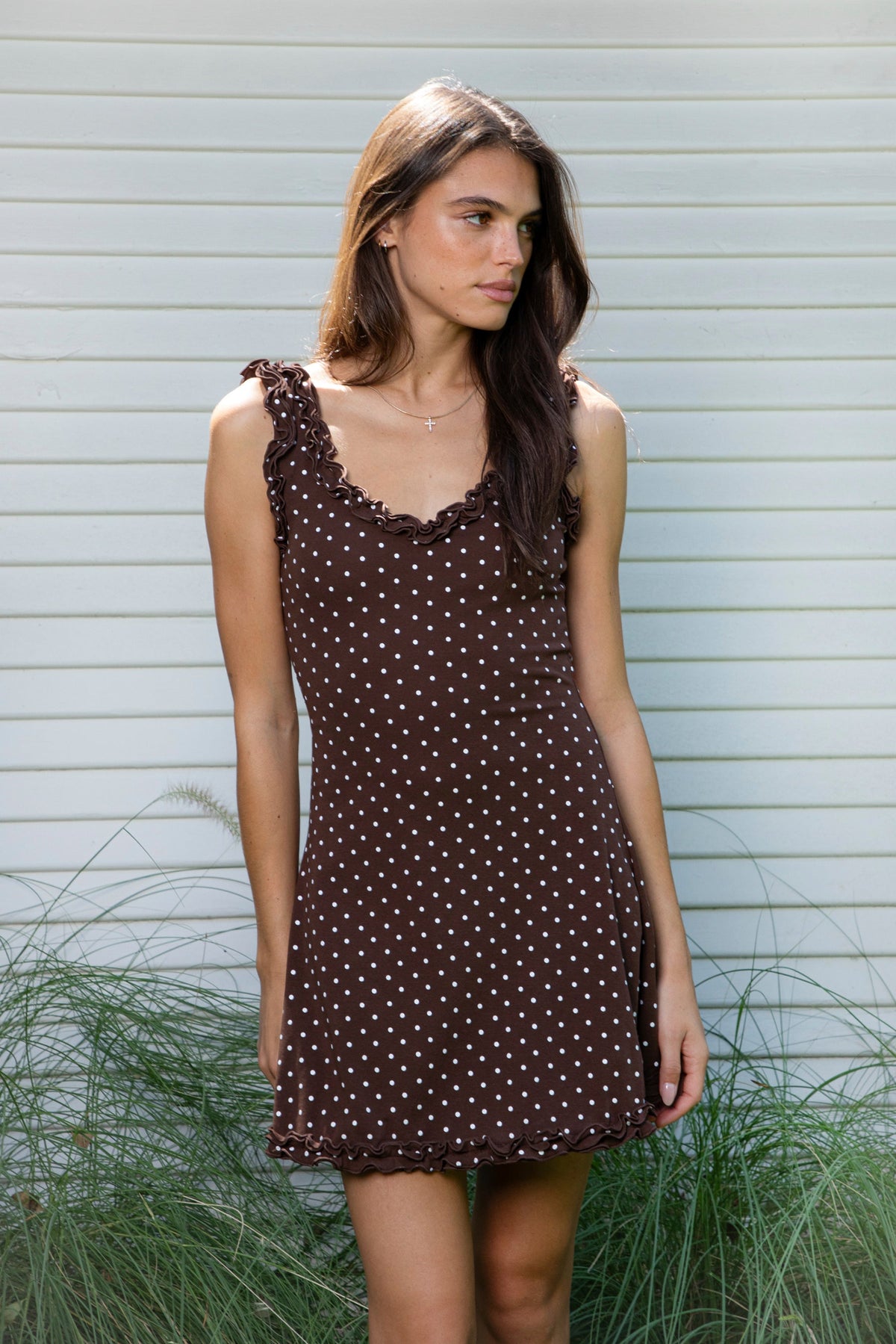 Woman wearing MOXI ruffle polka dot stretch mini dress featuring soft stretch cotton jersey fabric, allover polka dot print, scoop neckline with layered ruffle trim, wide ruffled shoulder straps, fitted bodice, softly flared skirt, and double ruffle trim along the mini hem.