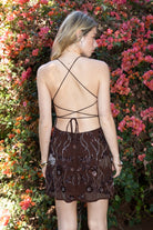 Woman wearing TIC TOC DL31853 VEDA chiffon sequin beaded lace-up mini dress featuring intricate floral bead and sequin embroidery, a flattering V-neckline with slim halter strap, open back design with adjustable lace-up tie, and a body-skimming mini silhouette for a radiant festival and summer night-out look.