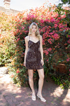 Woman wearing TIC TOC DL31853 VEDA chiffon sequin beaded lace-up mini dress featuring intricate floral bead and sequin embroidery, a flattering V-neckline with slim halter strap, open back design with adjustable lace-up tie, and a body-skimming mini silhouette for a radiant festival and summer night-out look.