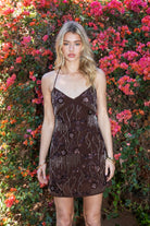 Woman wearing TIC TOC DL31853 VEDA chiffon sequin beaded lace-up mini dress featuring intricate floral bead and sequin embroidery, a flattering V-neckline with slim halter strap, open back design with adjustable lace-up tie, and a body-skimming mini silhouette for a radiant festival and summer night-out look.