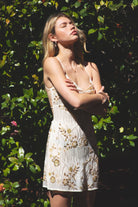 Woman wearing TIC TOC DL31853 VEDA chiffon sequin beaded lace-up mini dress featuring intricate floral bead and sequin embroidery, a flattering V-neckline with slim halter strap, open back design with adjustable lace-up tie, and a body-skimming mini silhouette for a radiant festival and summer night-out look.